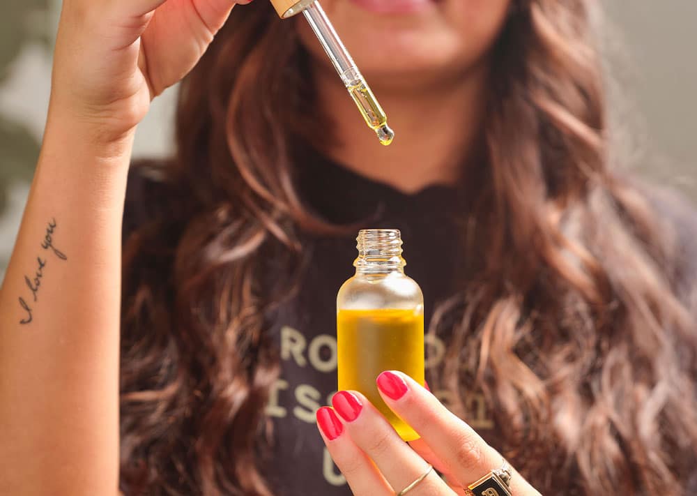 Women holding a Jar with dropper filled with THC Tincture