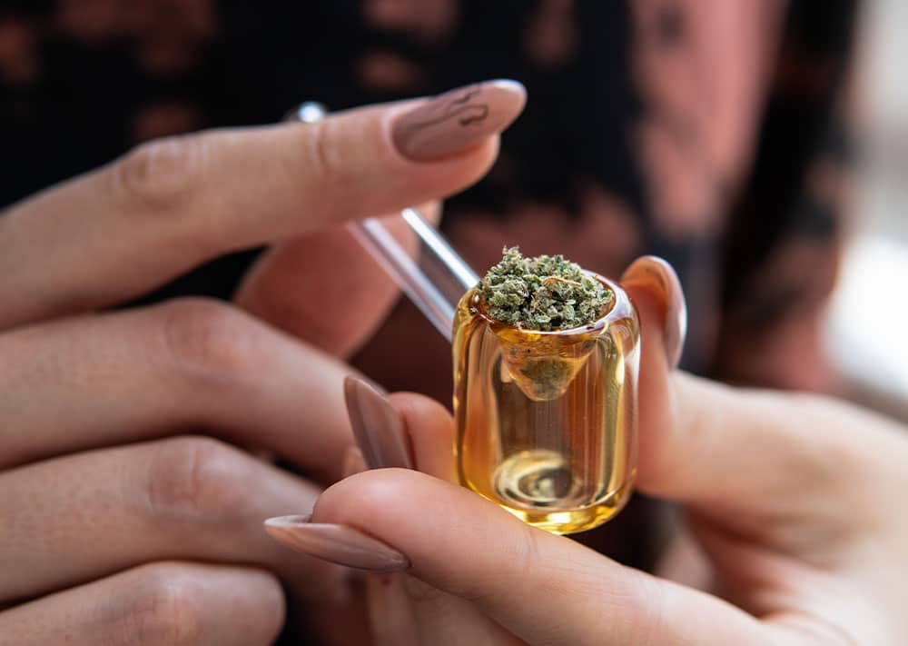 Woman holding a glass pipe with medical cannabis flower