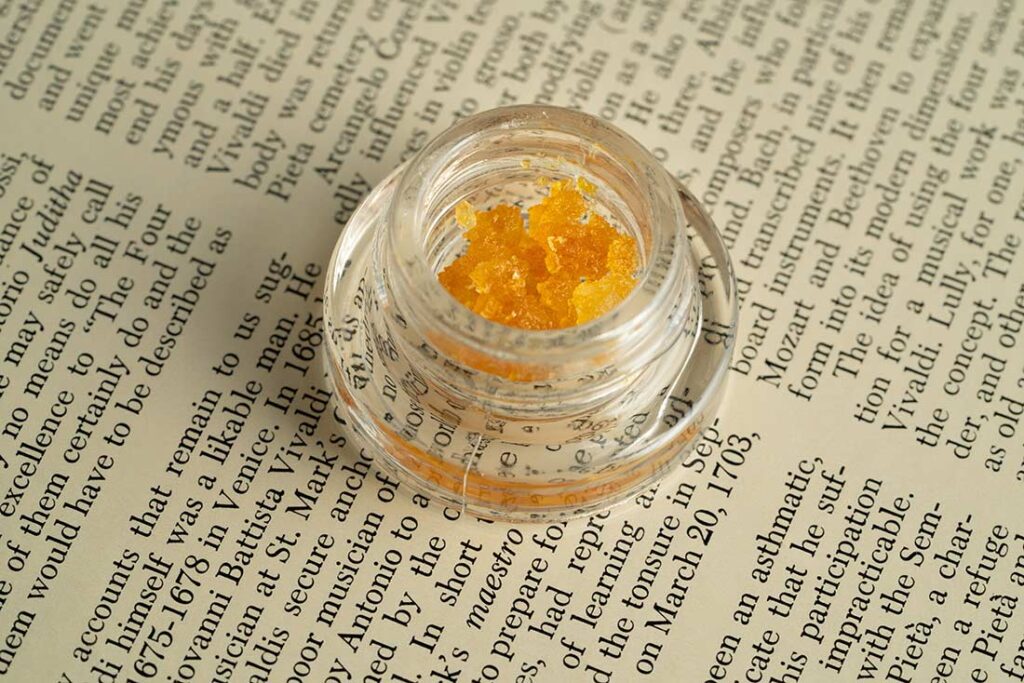 Cannabis Resin in a jar sitting on a page of text